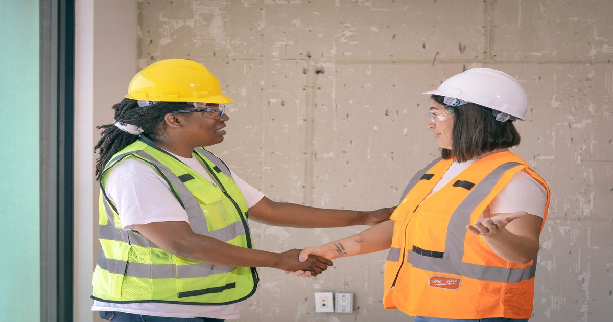 Propriétaire et tireur de joint discutant d'une soumission sur un chantier